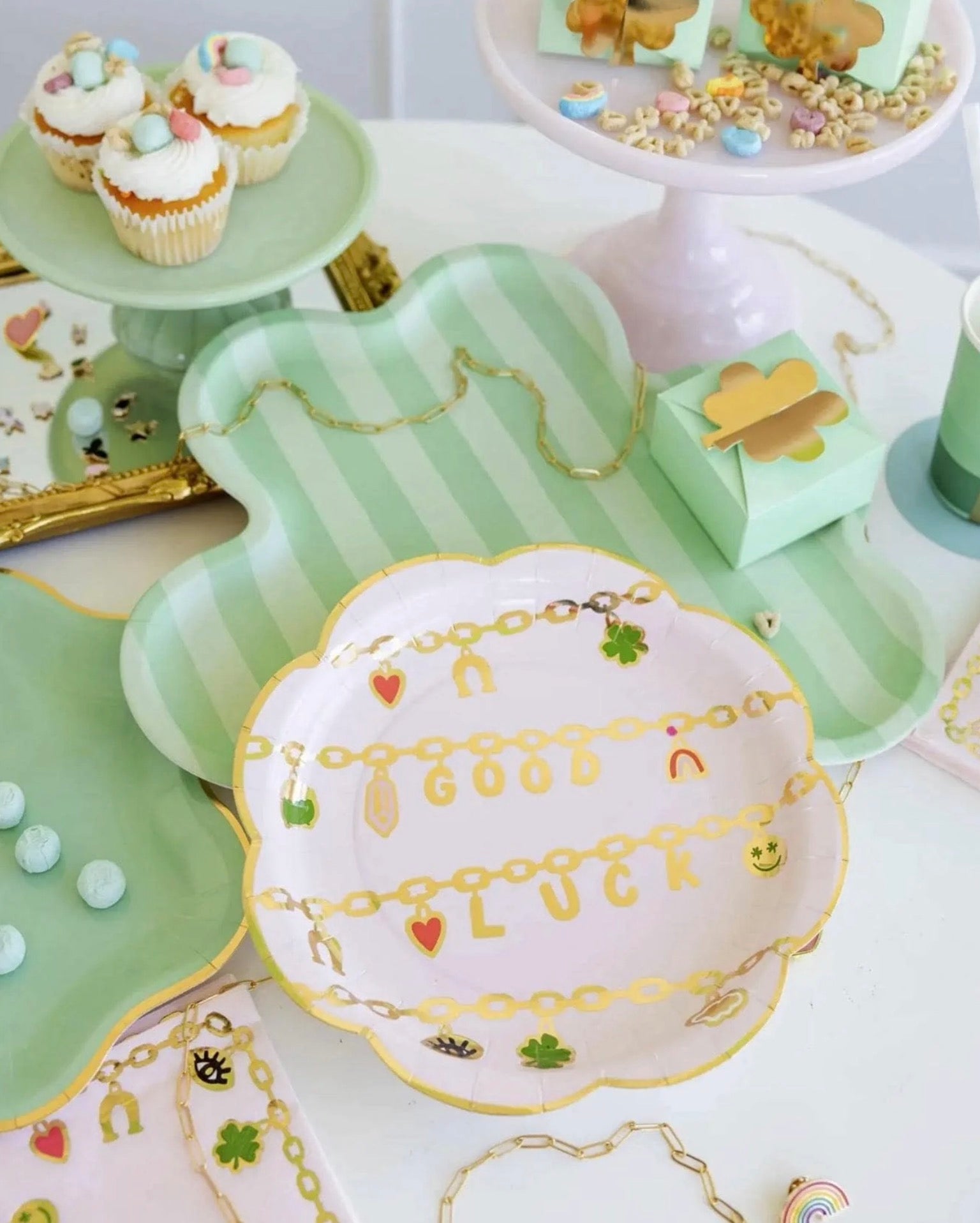 Decorative plates with gold accents and text on a table with pastries.