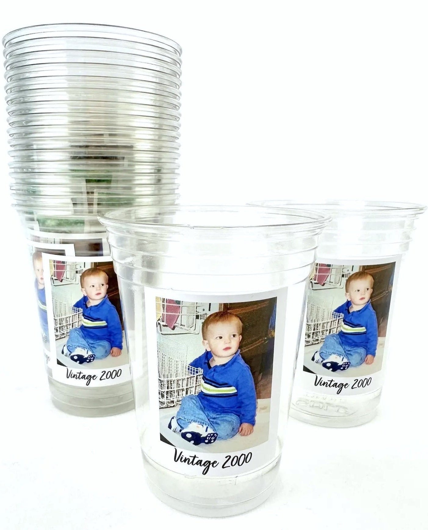 Clear plastic cups with printed images of a child and 'Vintage 2000' text on a white background.