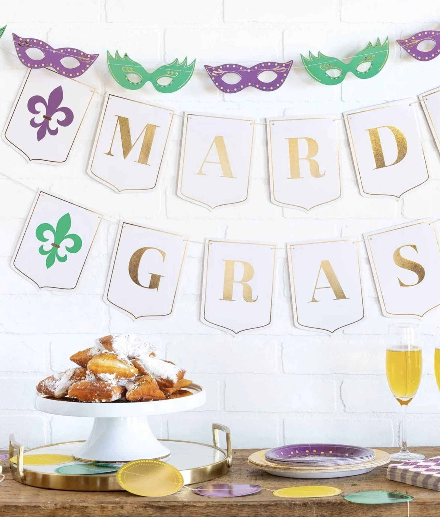 Mardi Gras-themed decorations with masks, banners, and pastries on a table.
